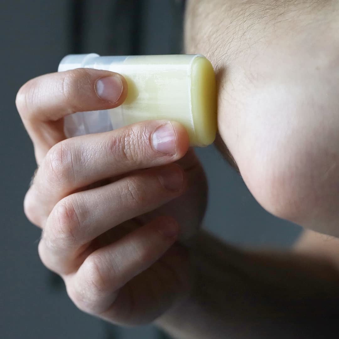 a person using the moisturizer stick on their elbow
