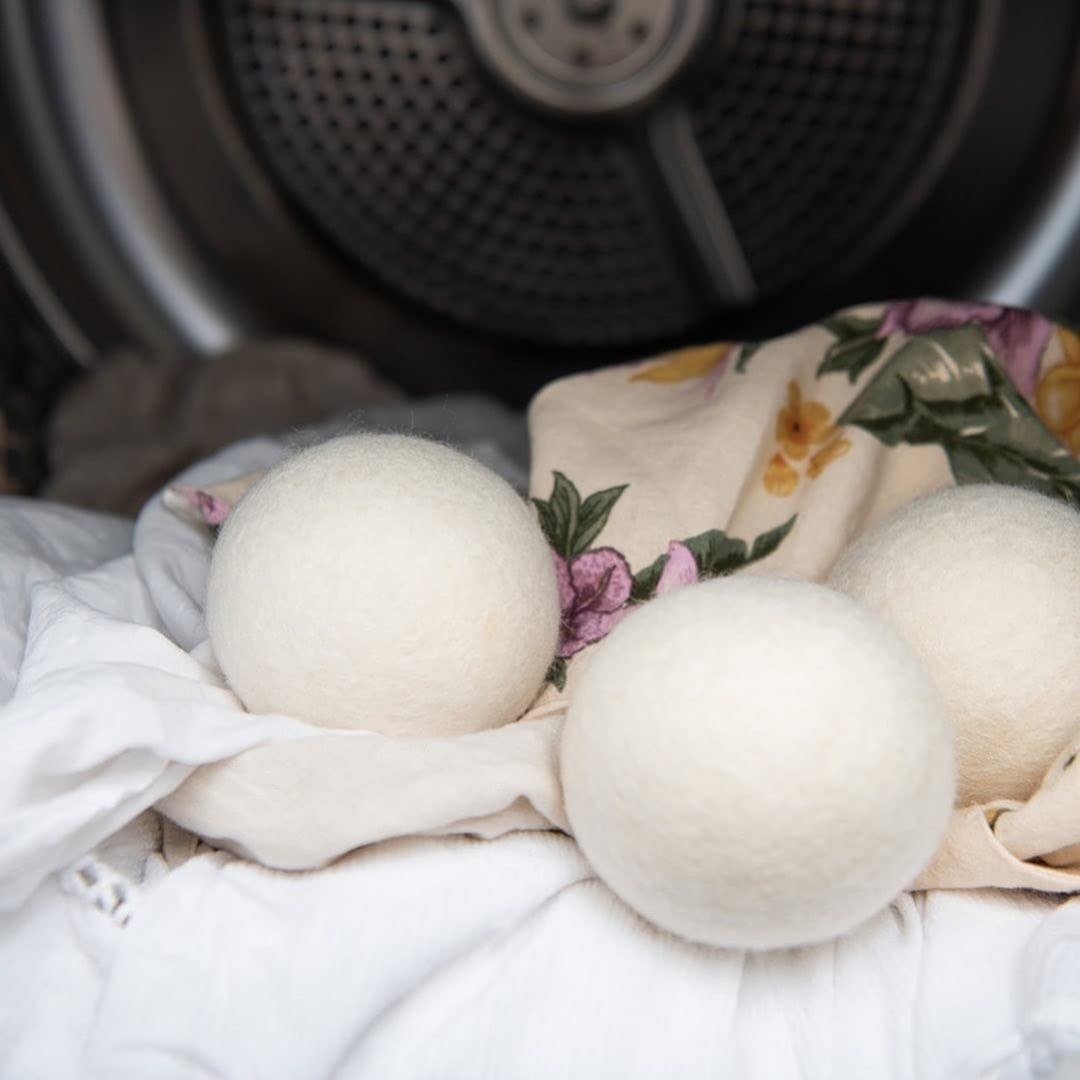 three wool dryer balls in a dryer full of clothes
