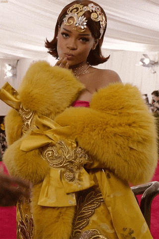Rihanna blows a kiss wearing an iconic, poofy yellow dress at the Met Gala