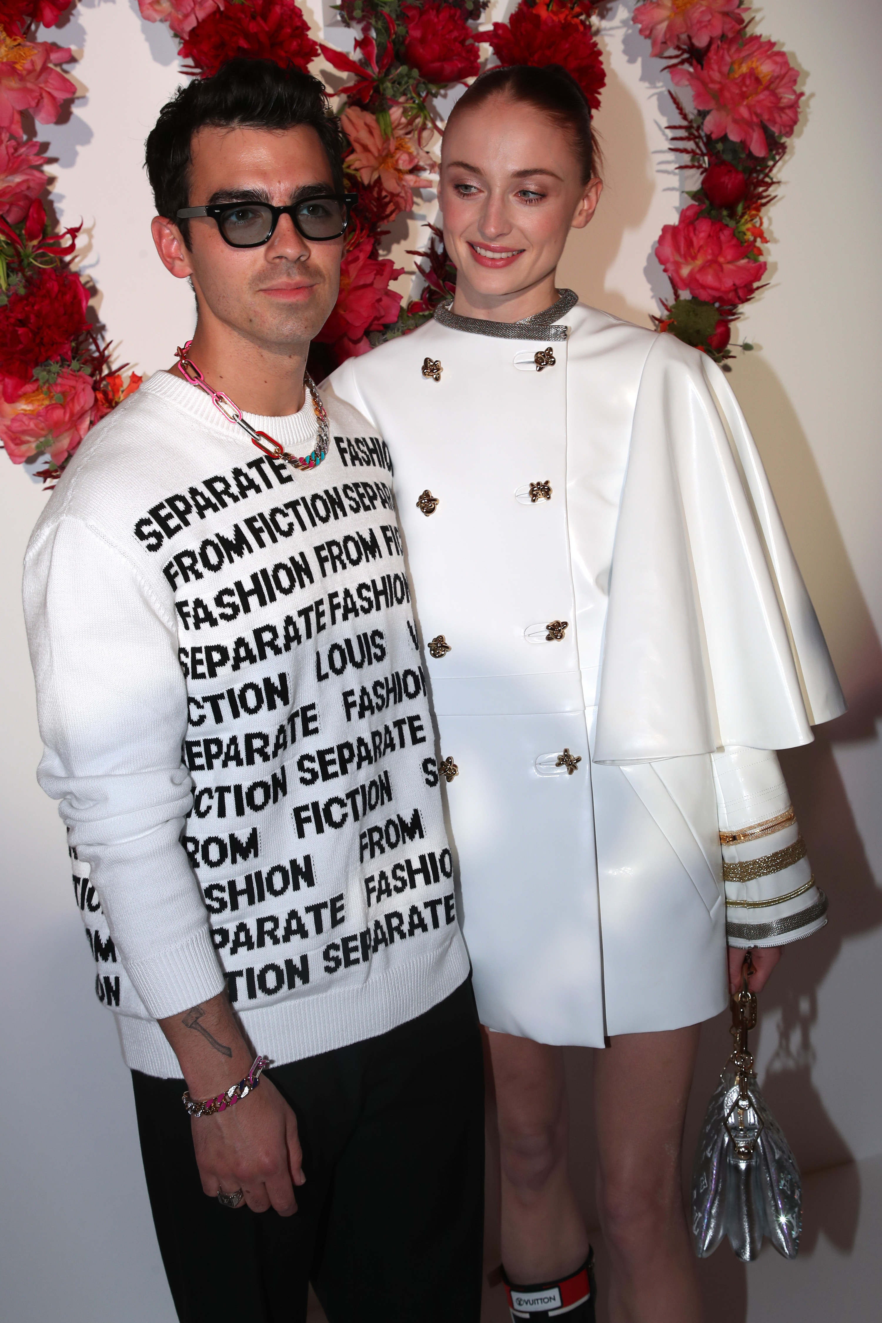 Joe and Sophie pose for a photo together in front of roses