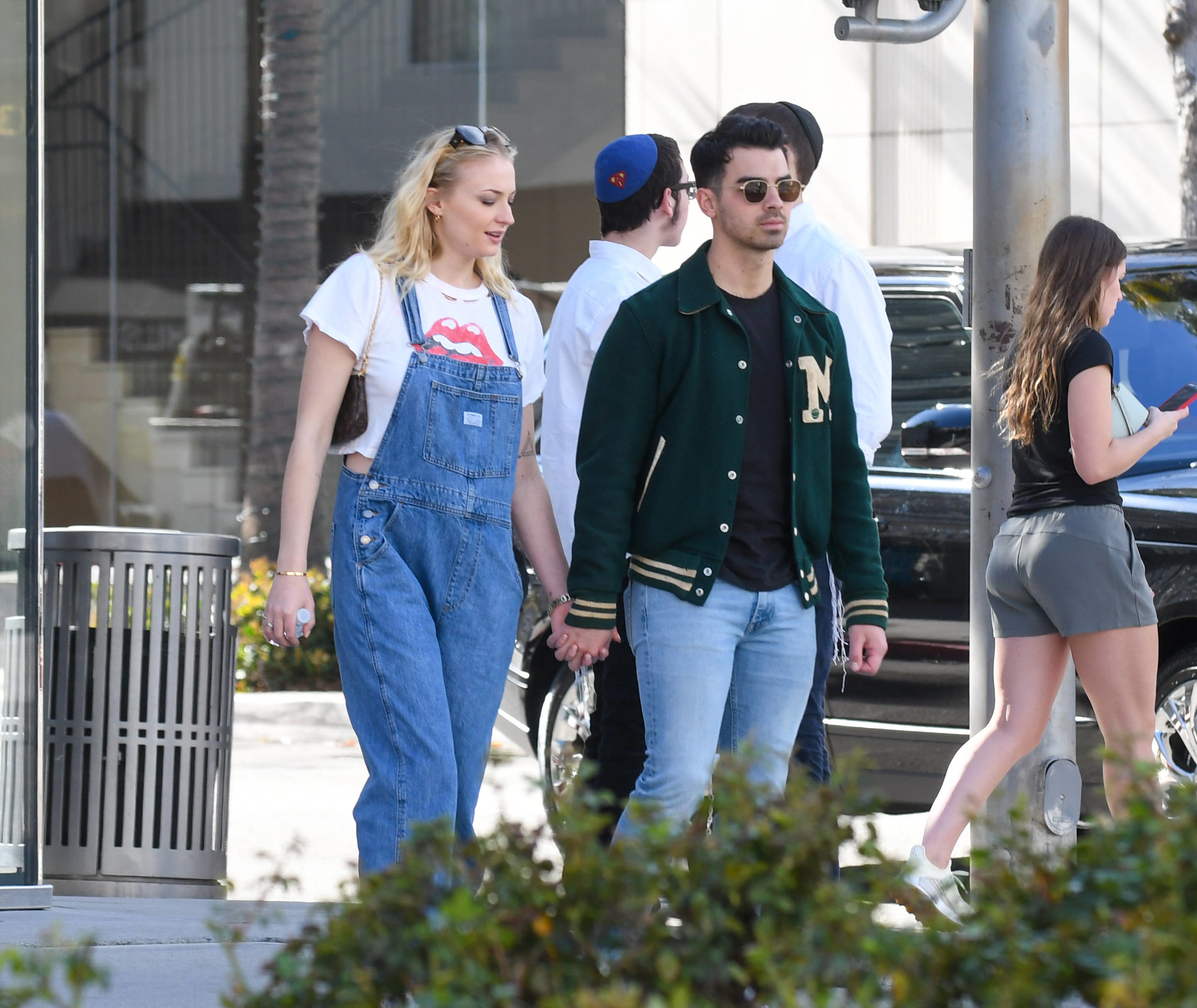 Joe and Sophie walk down the street and hold hands