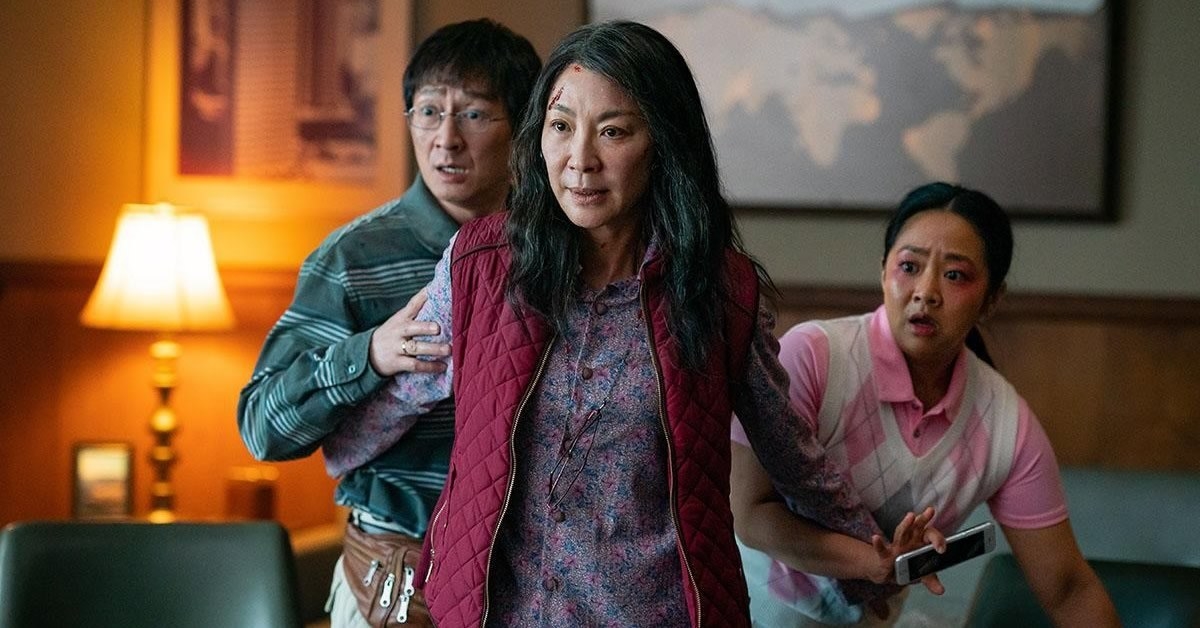 Michelle Yeoh as Evelyn standing, looking protective, in front of Stephanie Hsu as Joy and Ke Huy Quan as Waymond