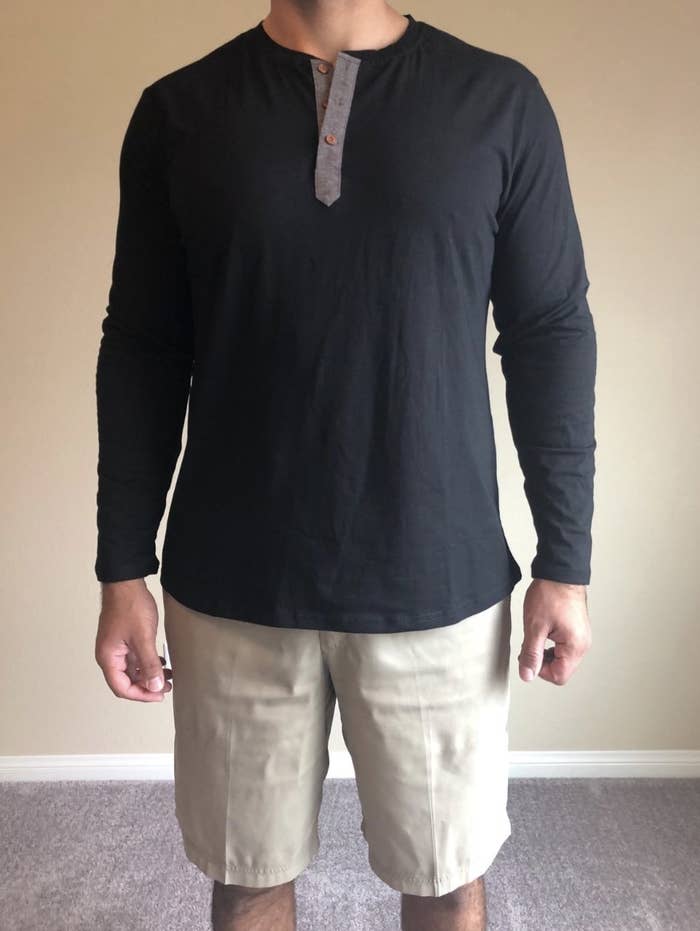 reviewer wearing the henley in black with a pair of khaki shorts