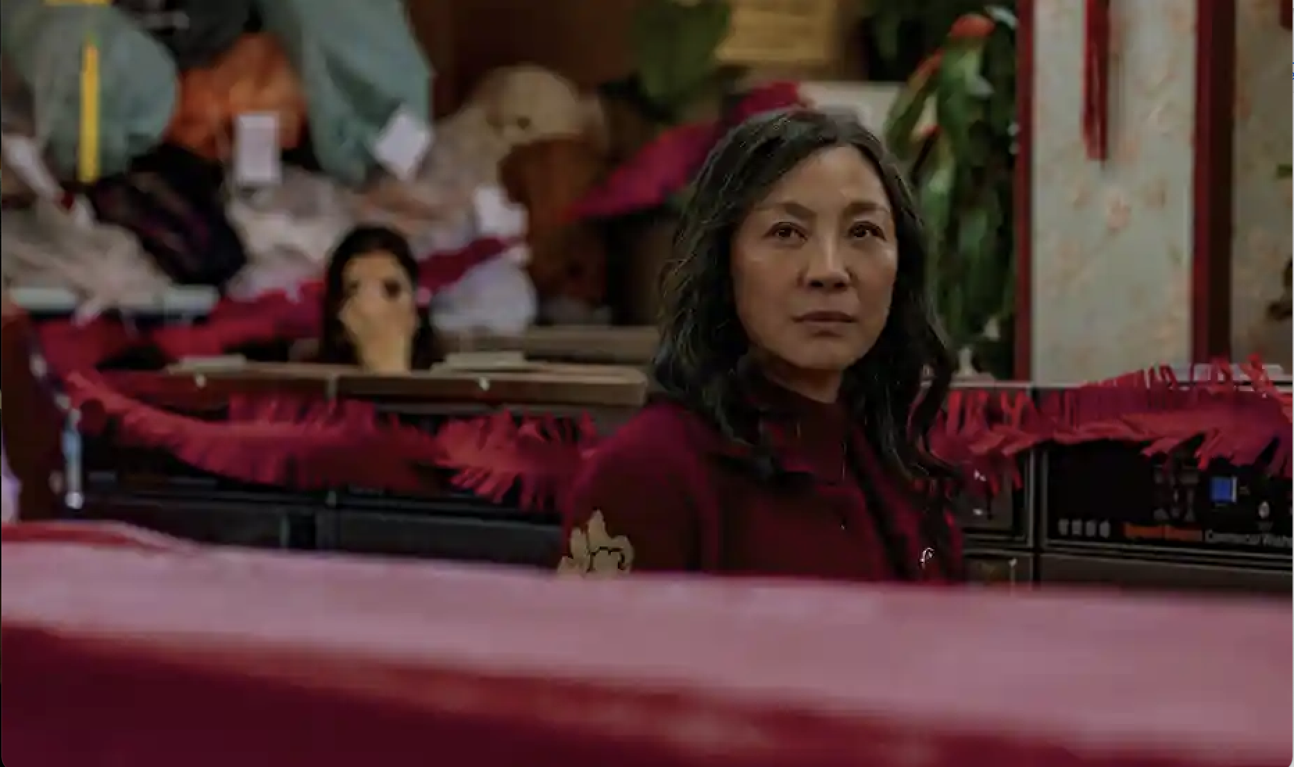 Michelle Yeoh as Evelyn looking pensively across the room