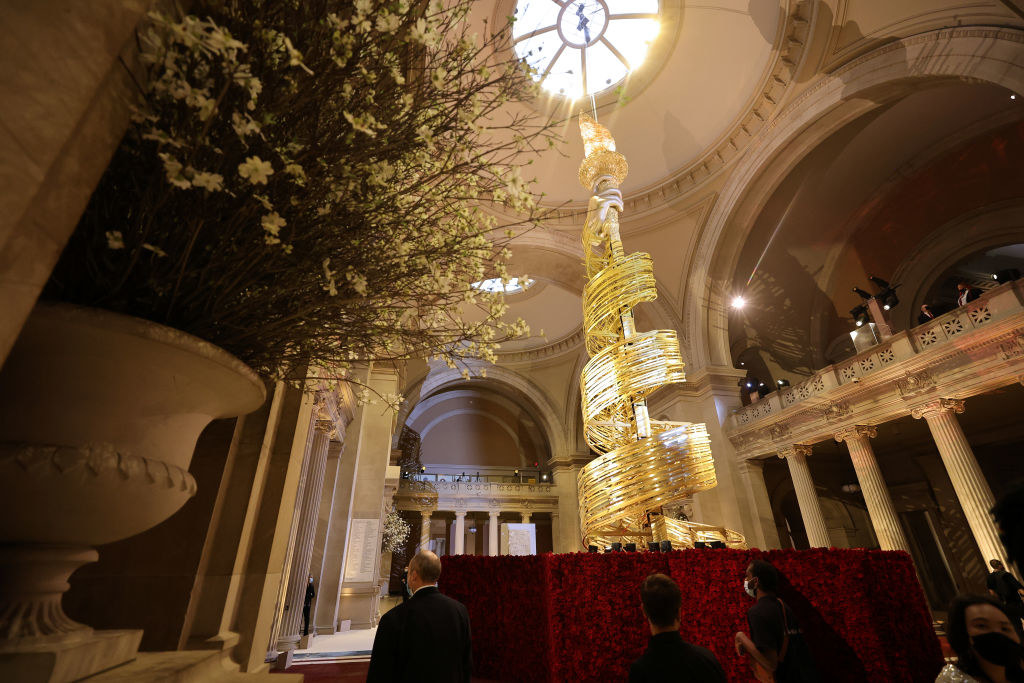 The arm of the Statue of Liberty, with golden swirls running from the torch down the length of the arm