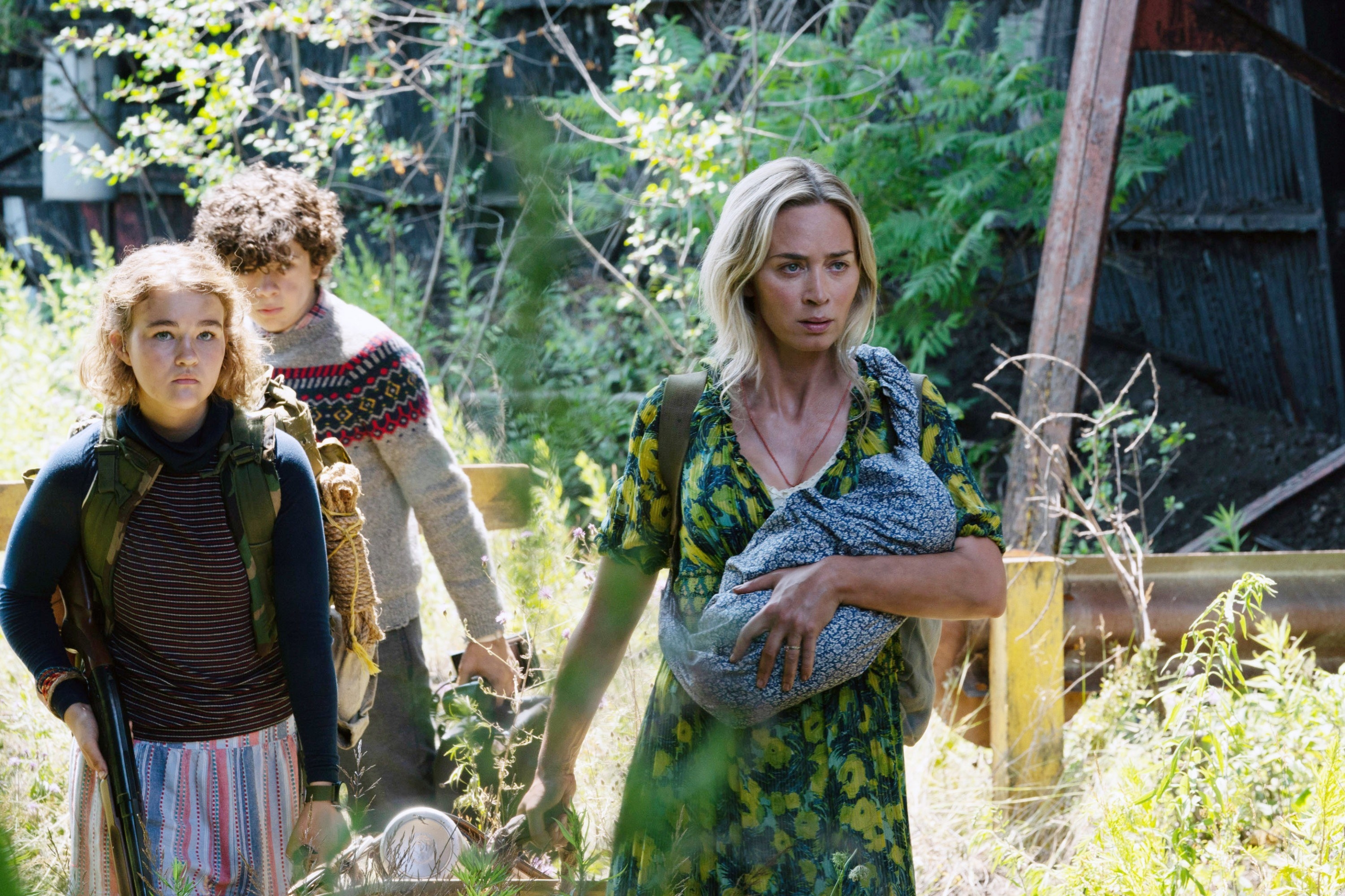 Emily Blunt leads Millicent Simmonds and Noah Jupe through weeds