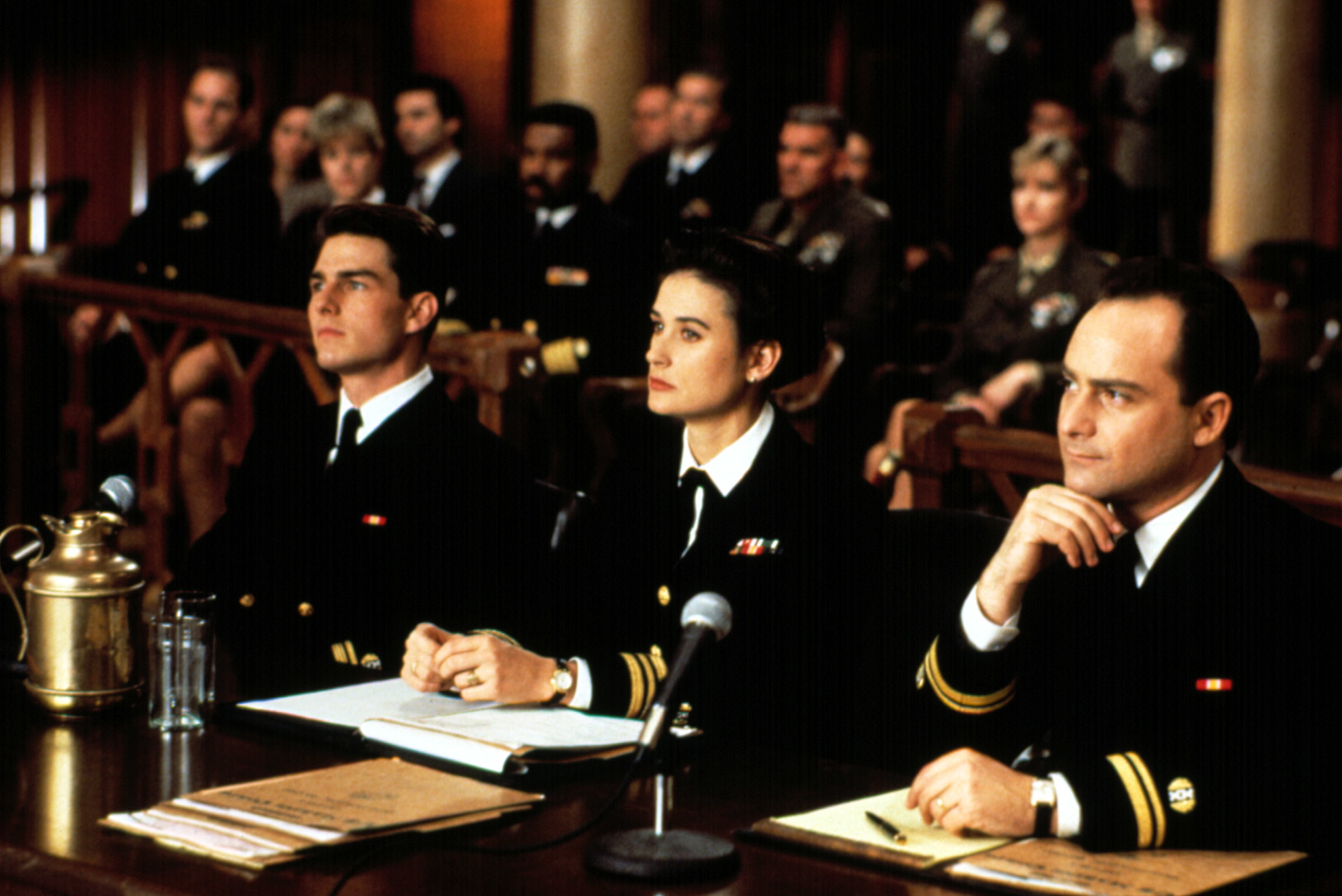 Tom Cruise, Demi Moore, and Kevin Pollak sit in a court room