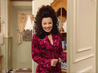 a gif of fran drescher from the nanny twirling happily in a kitchen