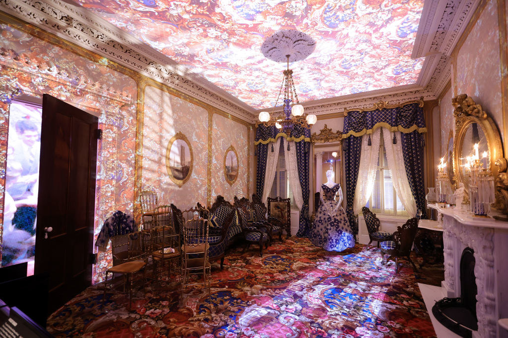 An old timey–looking room with colorful images projected on the floor and ceiling