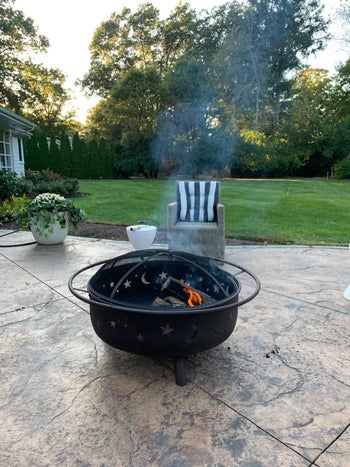 a black fire pit with moons and stars etched into the sides