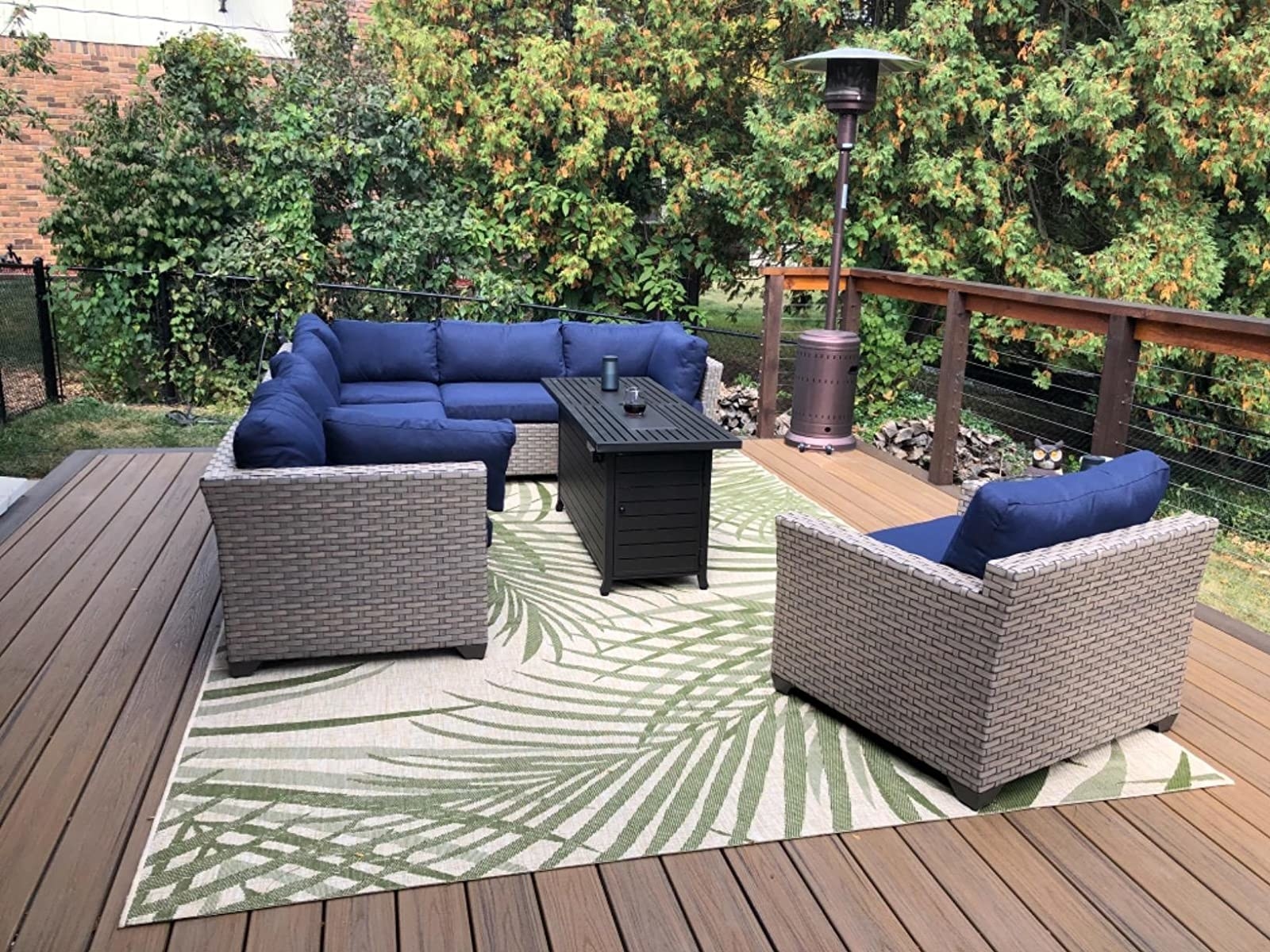 a white and green fern patterned rug underneath patio furniture