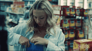 GIF woman pulling money out of her bra
