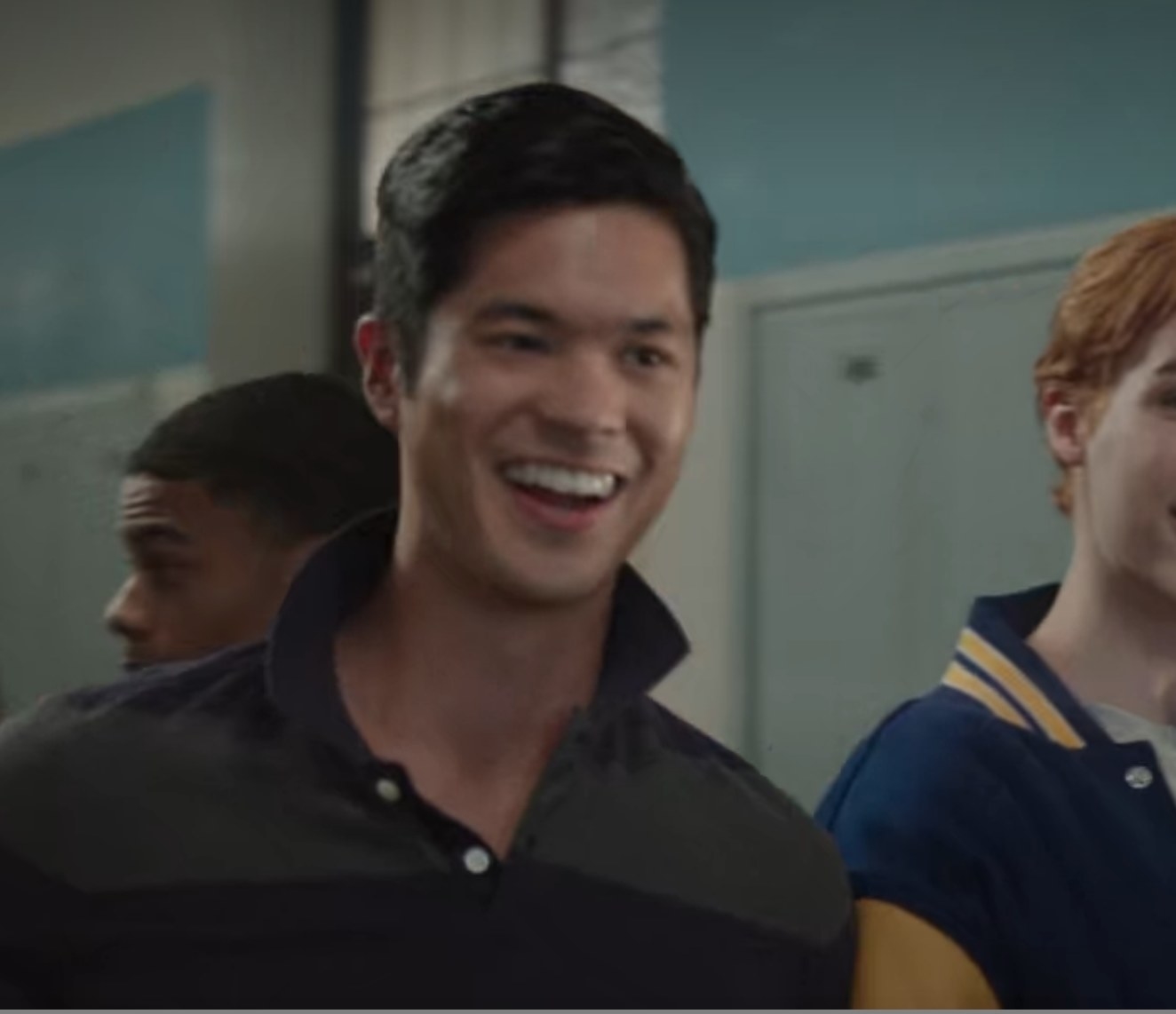 Ross Butler as Reggie laughs in the school hallway