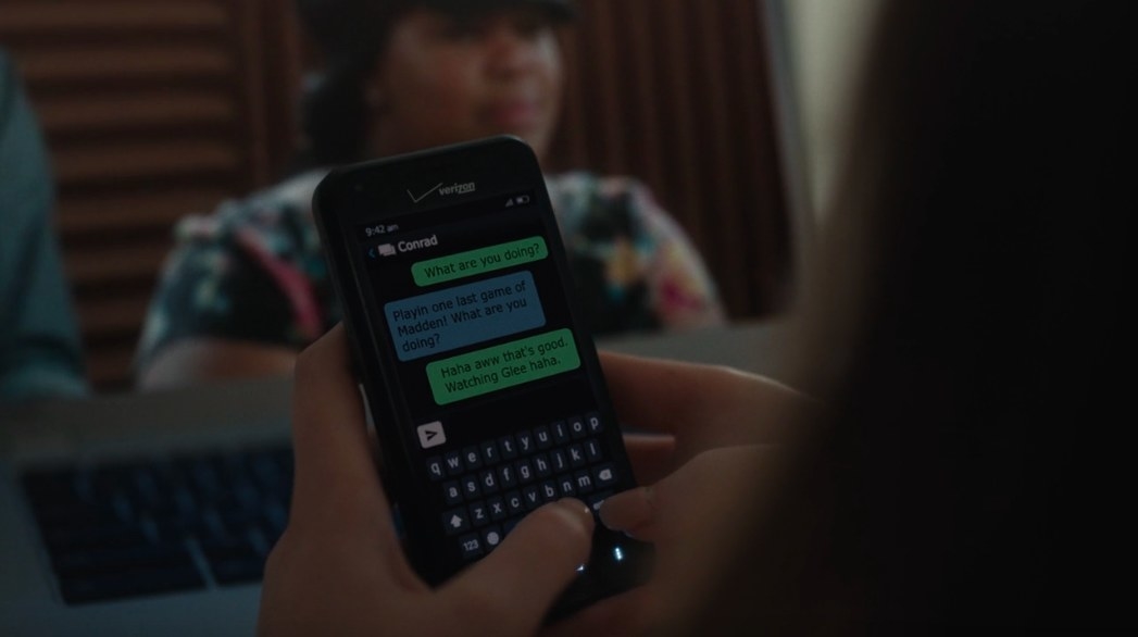 Michelle texts Conrad that she is watching Glee, shown on her laptop in the background