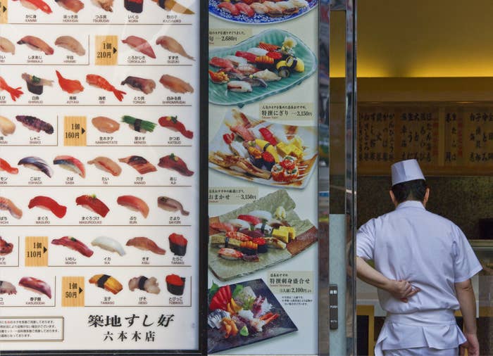A chef next to a sushi restaurant in Japan