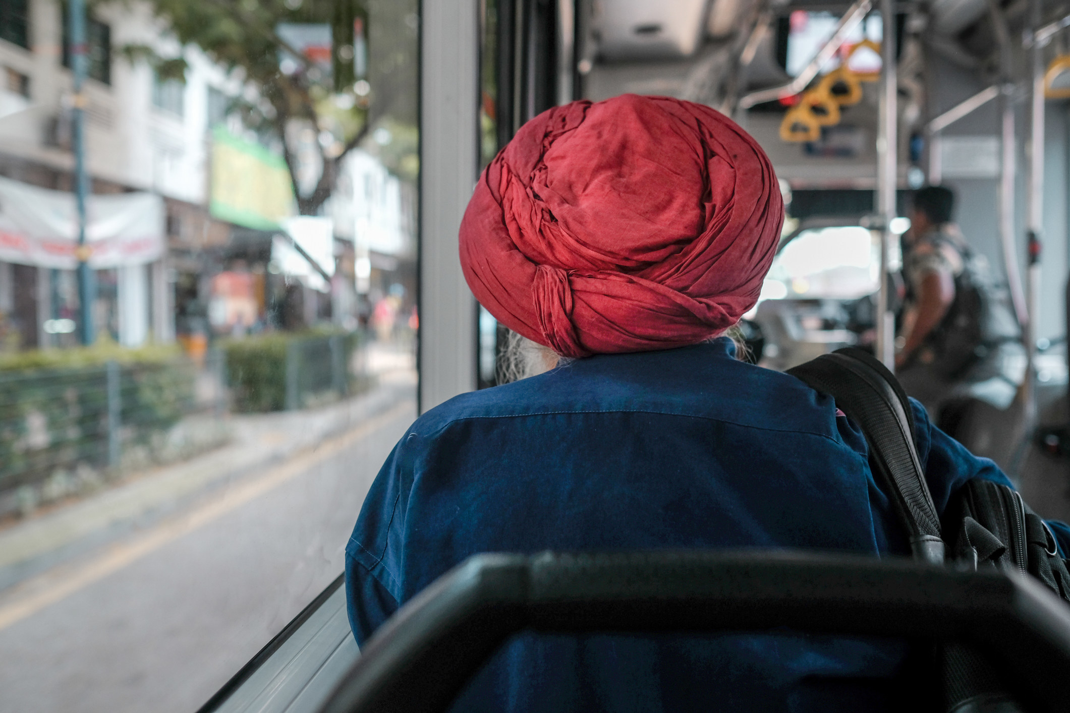 A man wearing a turban sitting on a bus