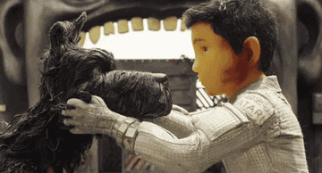 A boy hugging a dog in Isle of Dogs