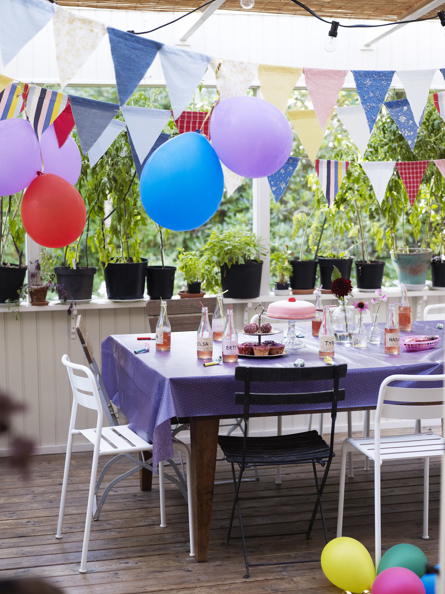 A birthday party set up on an outdoor deck with balloons