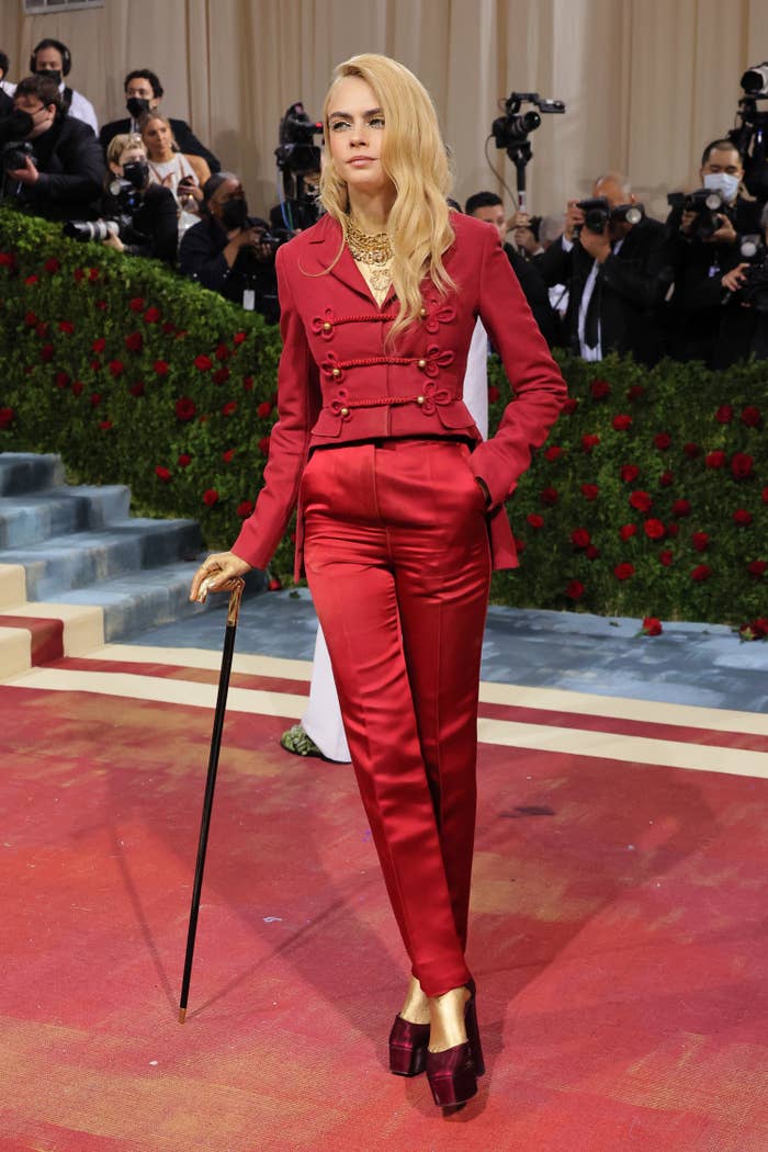 Cara wears red tail coat with red silk trousers and carries a cane