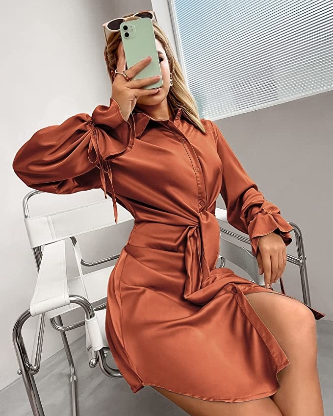 A person sitting in a chair and taking a selfie in the shirtdress