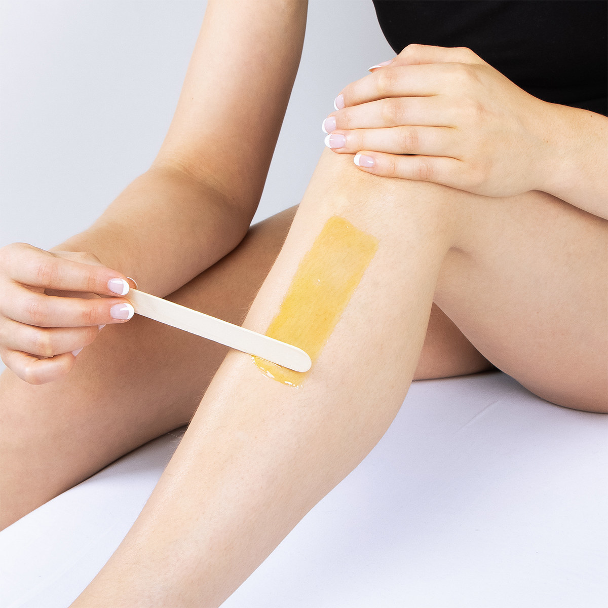 A person applying wax to their leg
