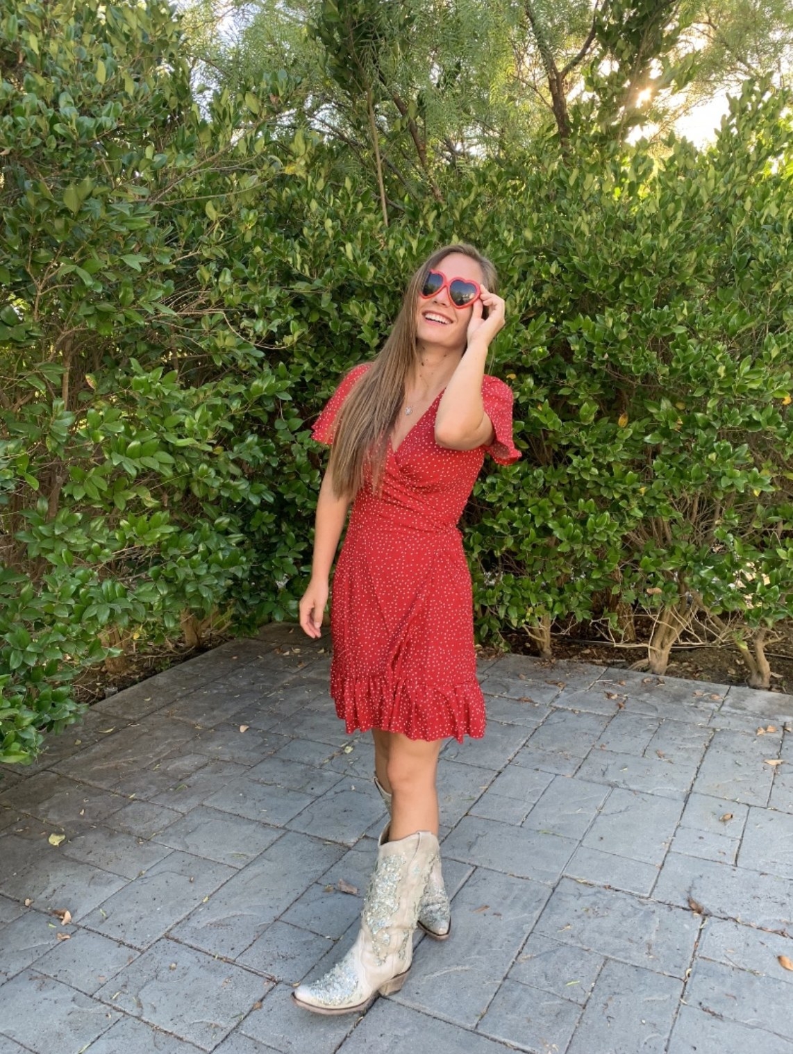 Reviewer&#x27;s photo wearing the red polka dot wrap dress with cowboy boots