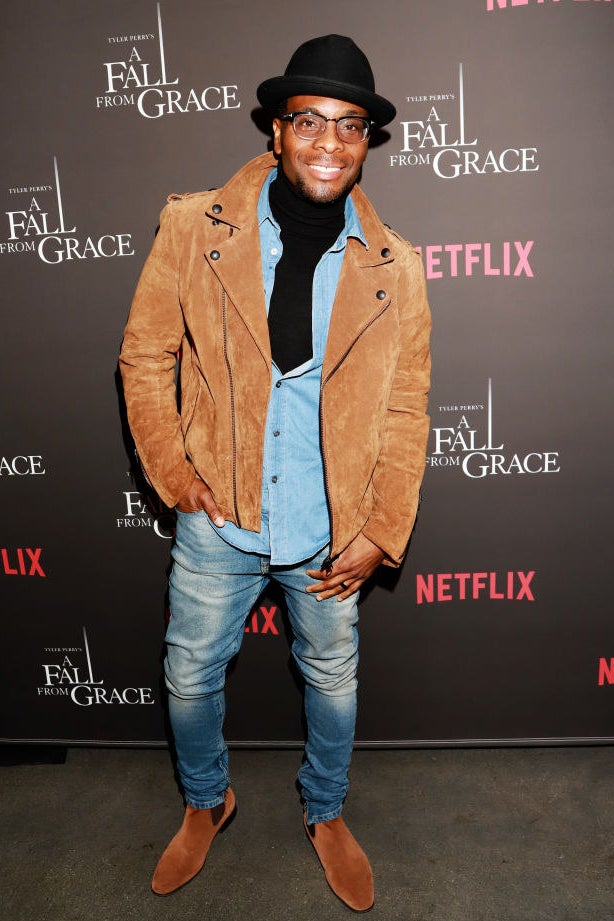 Smiling Kel in a hat and wearing jeans, a jean shirt, and a suede or corduroy jacket