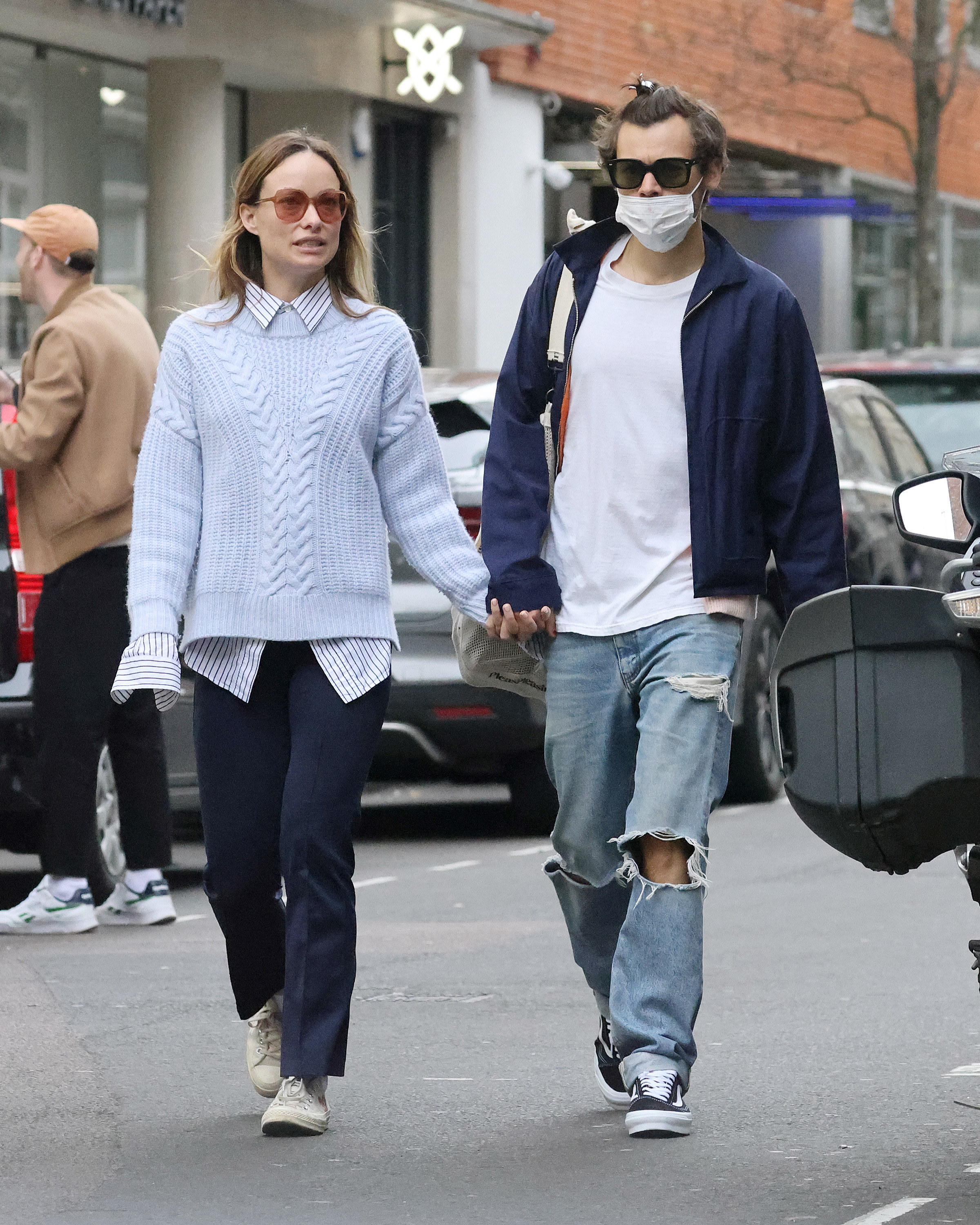 Olivia Wilde and Harry Styles walking down the street.