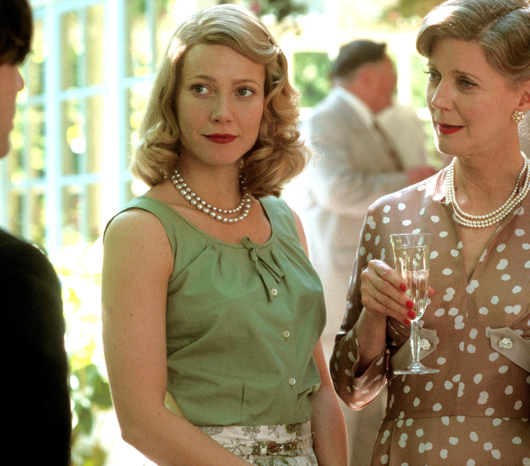 Blythe holds champagne while Gwyneth looks to the left