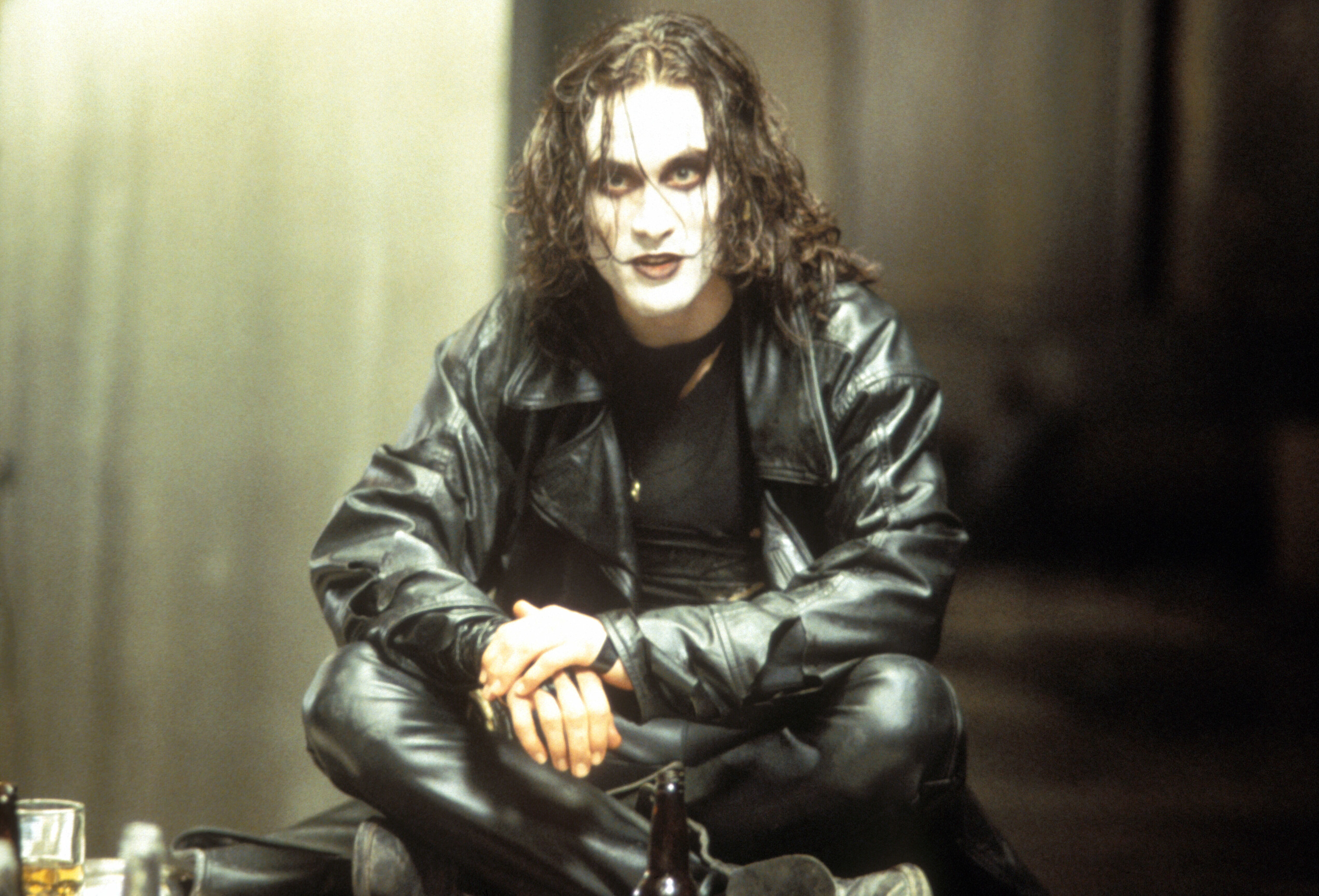 a man sitting cross-legged in all leather and paint on his face