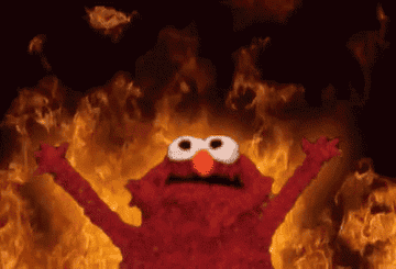 Elmo with his arms raised and flames behind him.