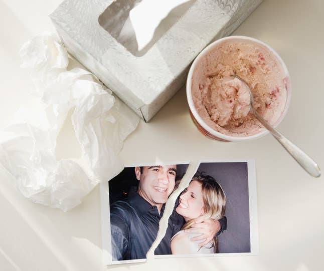 A pint of ice cream next to a couple&#x27;s torn photo.