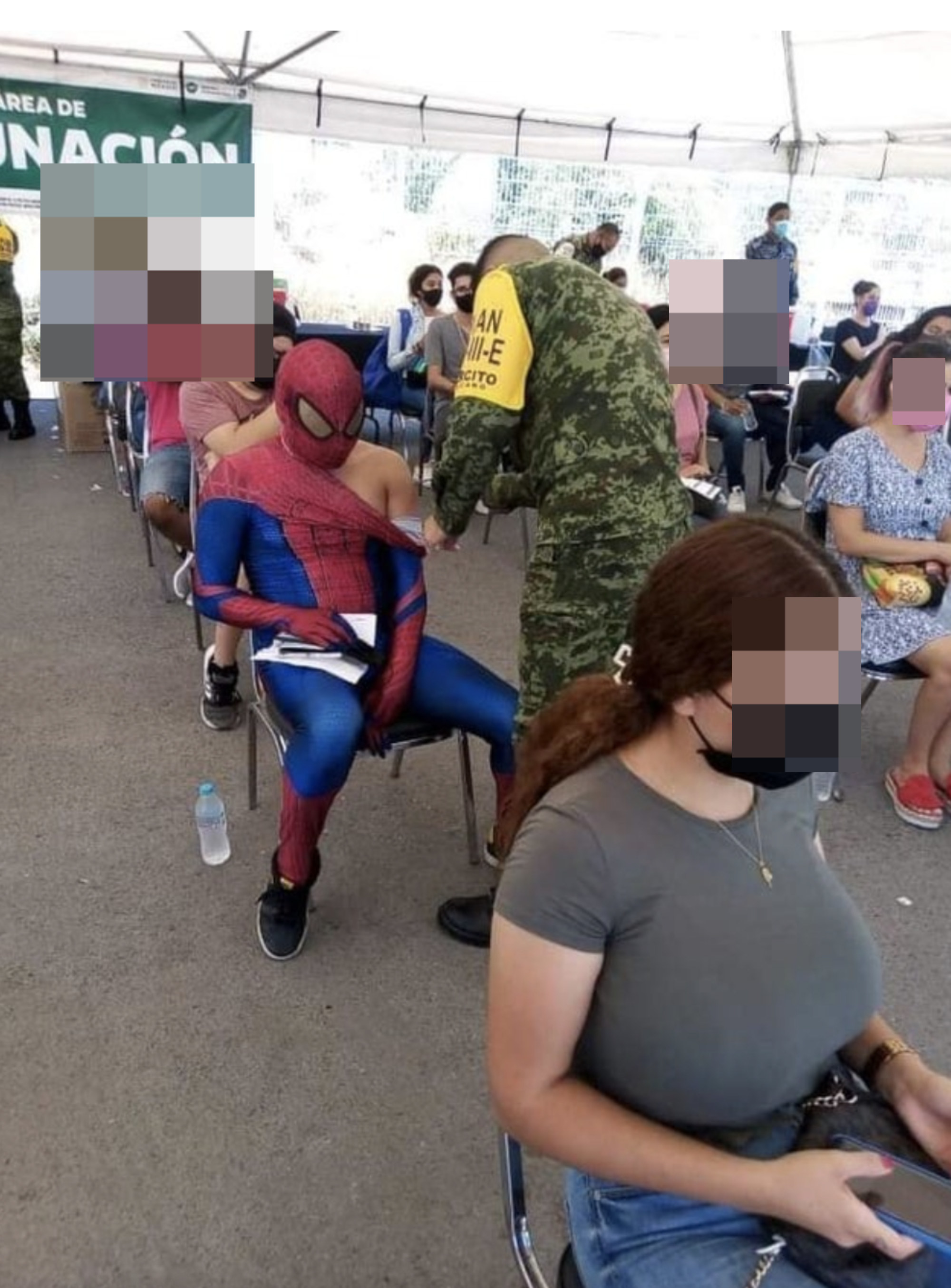 A man dressed as Spider-Man getting vaccinated.