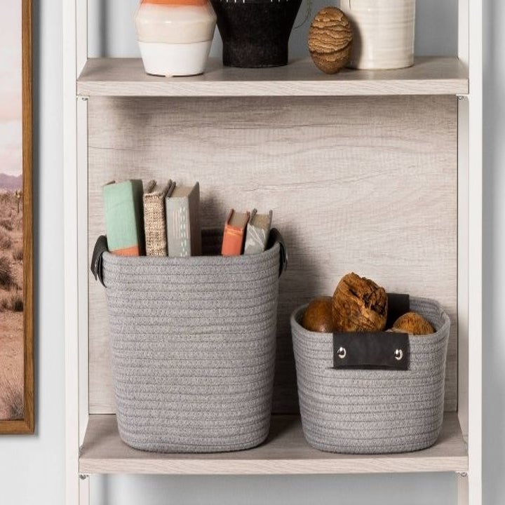 the gray rope baskets filled with stuff on a shelf