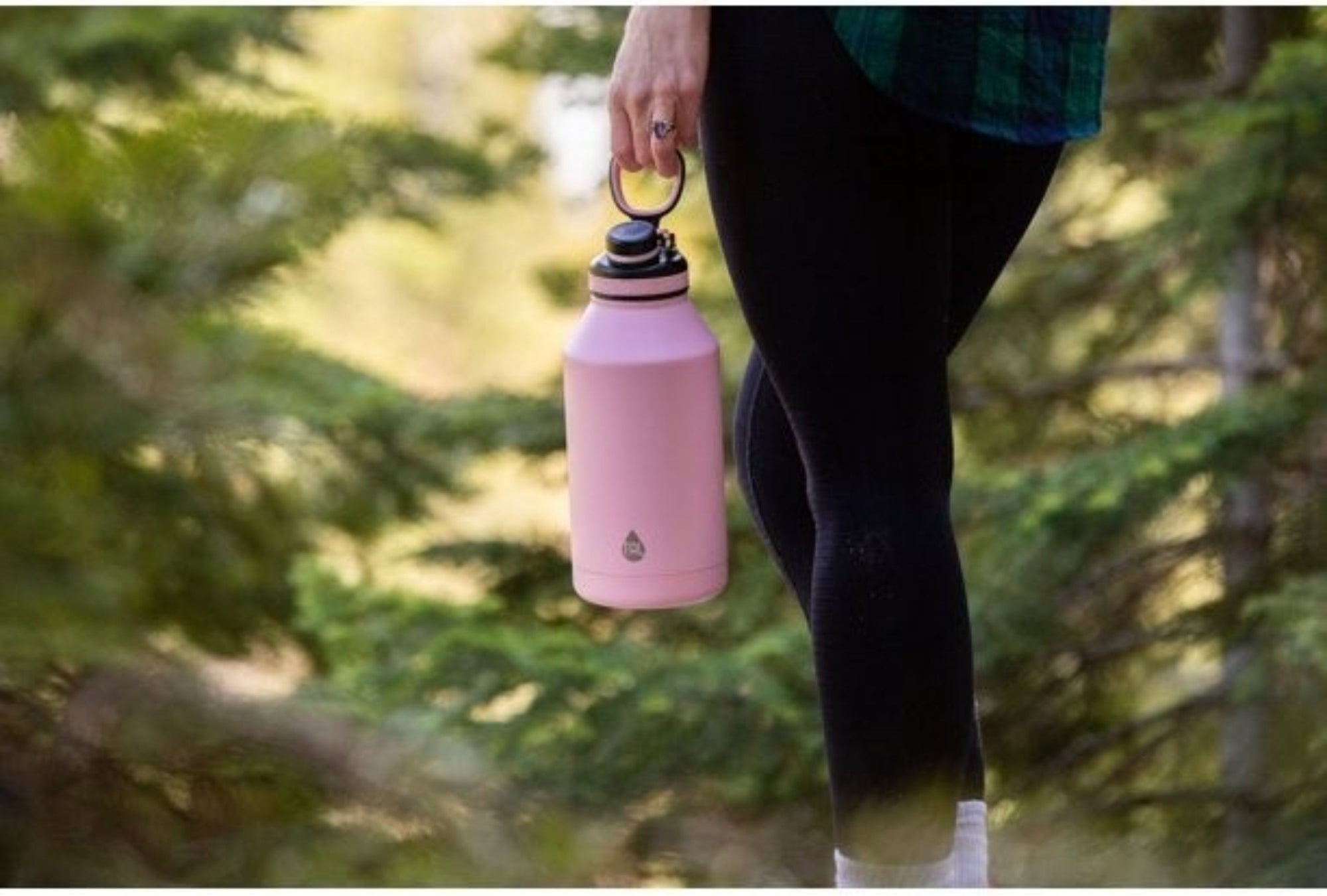Model holding pink bottle in the outdoors
