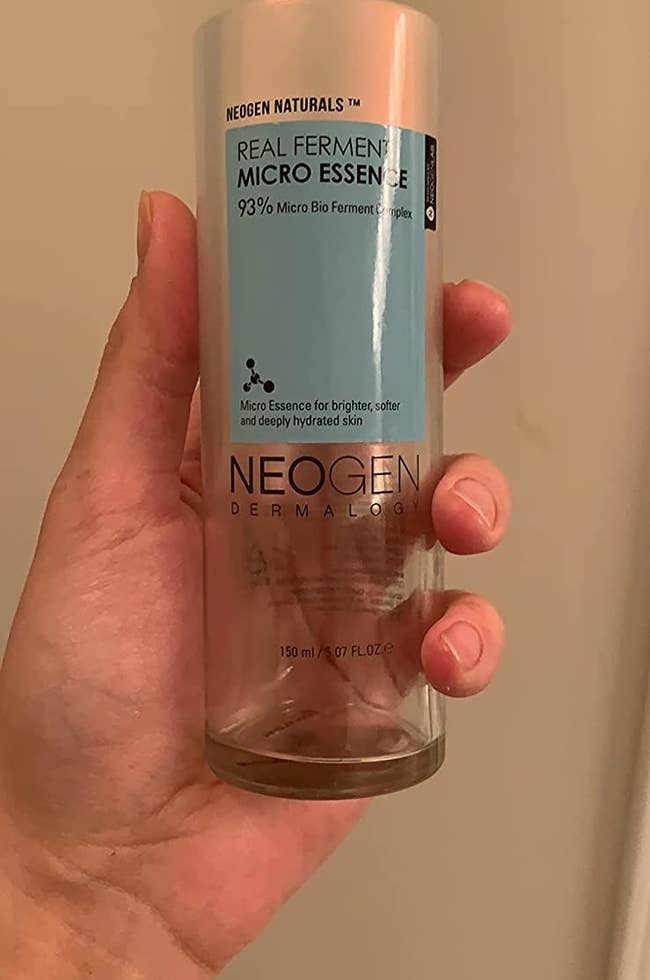 Reviewer holding bottle of Real Ferment Micro Essence