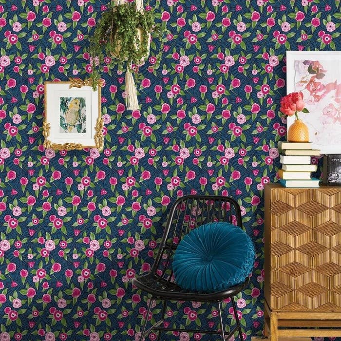 Navy and pink floral wallpaper on the wall of a styled room