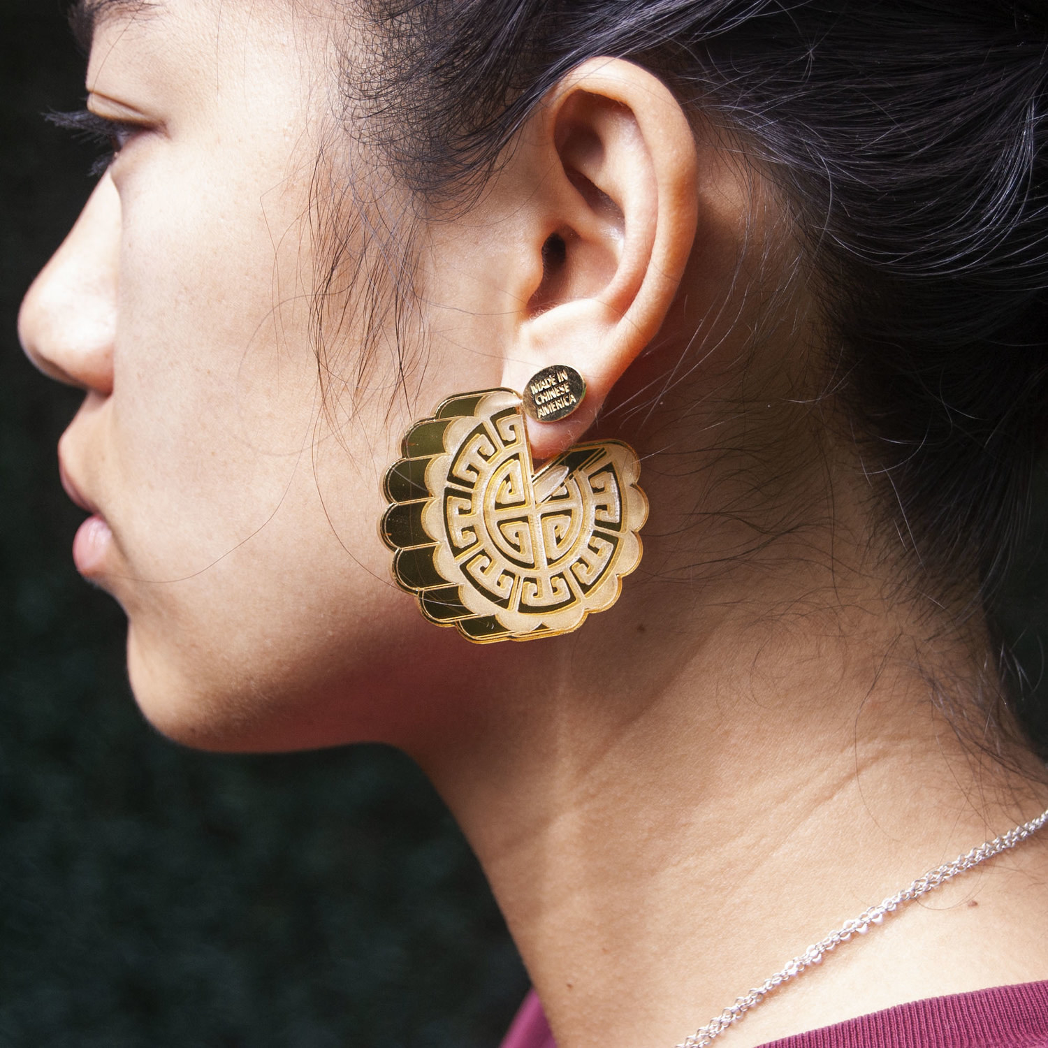 Large acrylic mooncake earrings shown on profile shot of model.