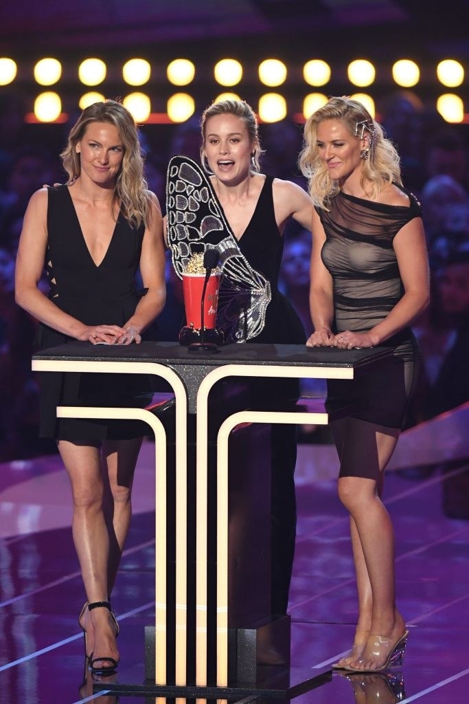 The three women all standing at the podium to accept the award