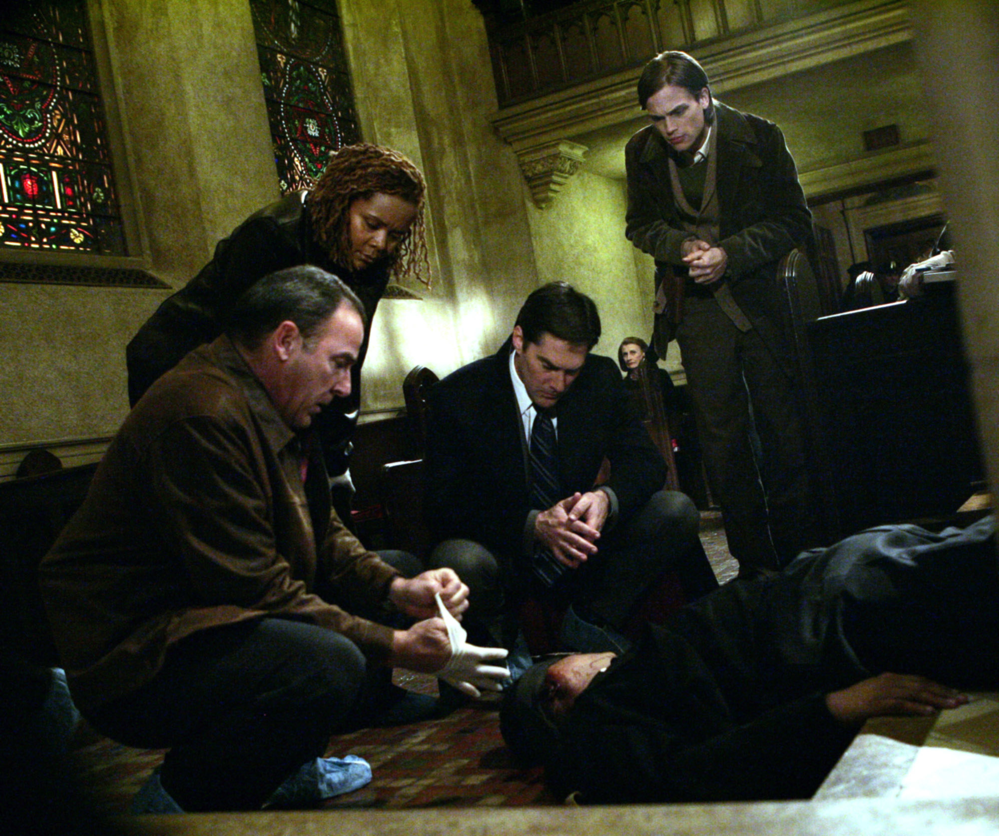 the characters leaning down and looking at a dead victim