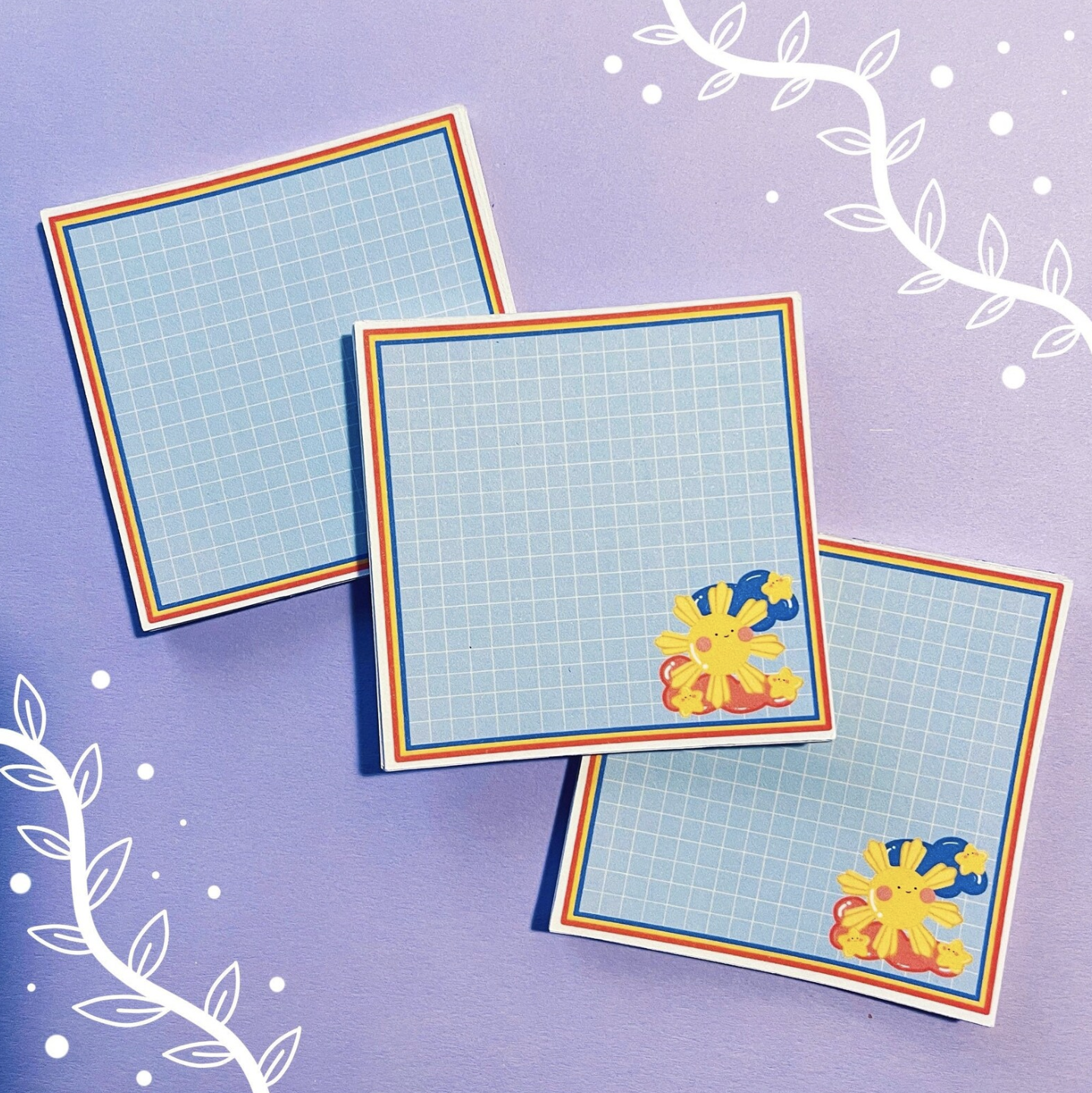 Sun and star characters on grid notepad displayed on a table.