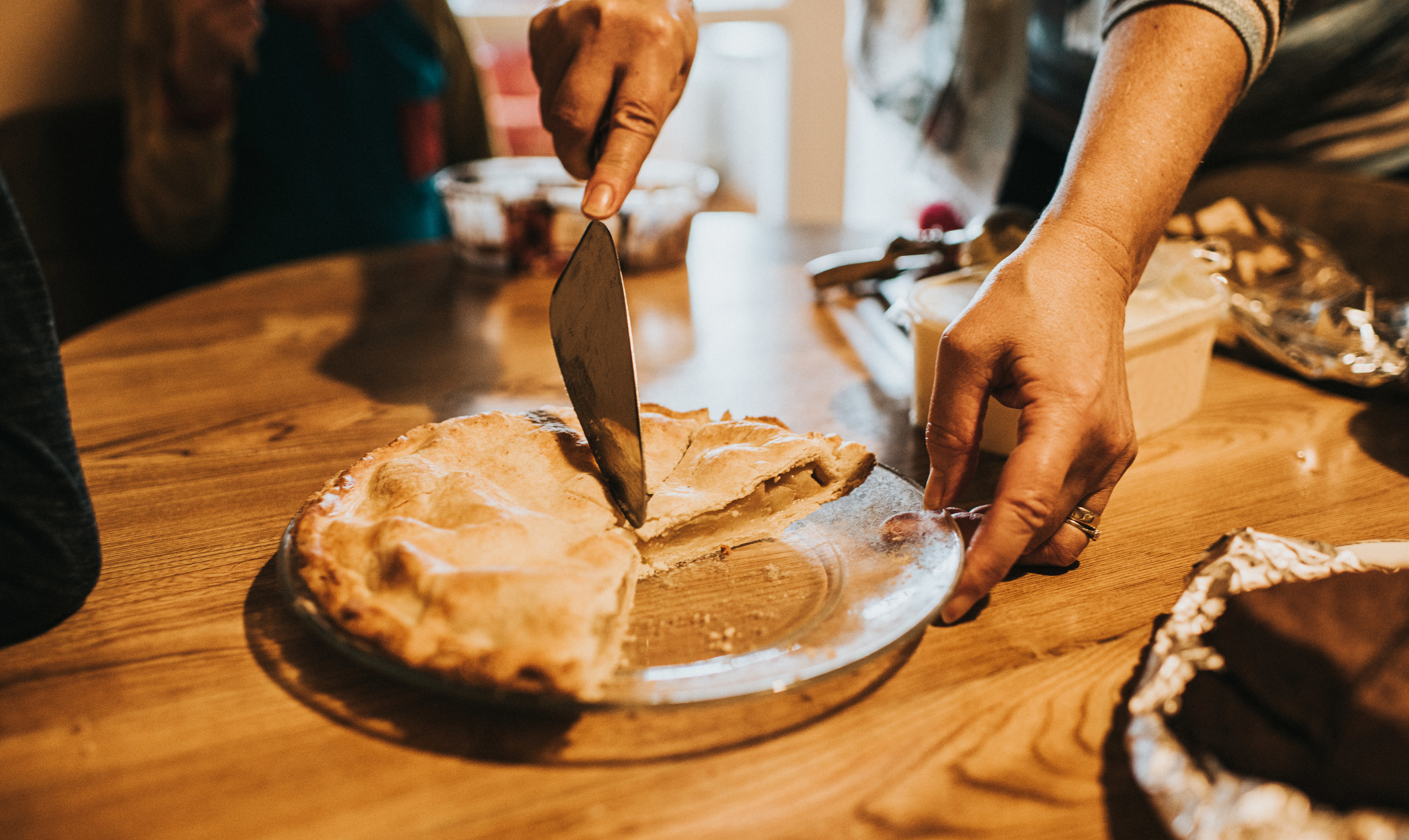 Hands cutting into a pie