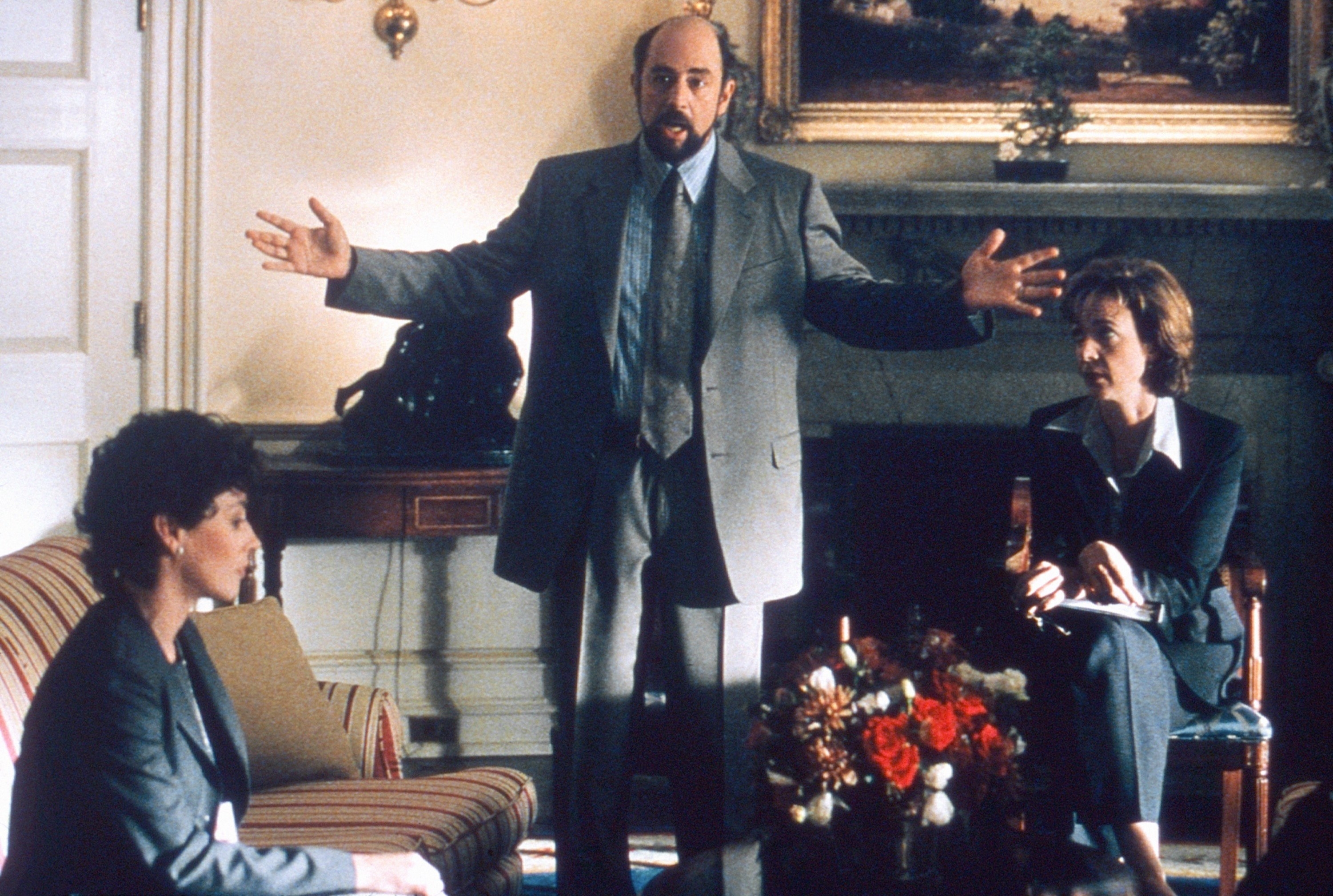 Toby with his arms stretched out while he talks in the oval office