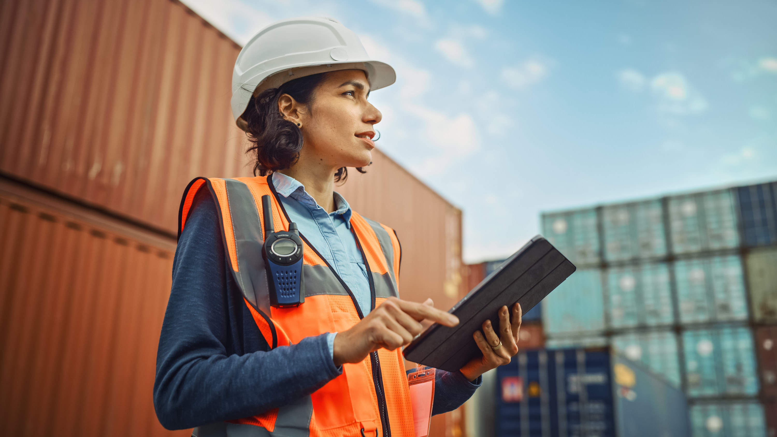 A woman wearing a hard hat and using an iPad