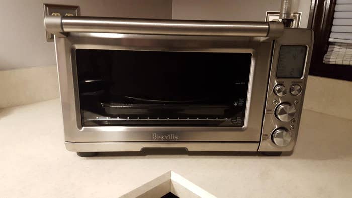reviewer&#x27;s photo of the stainless steel oven on countertop