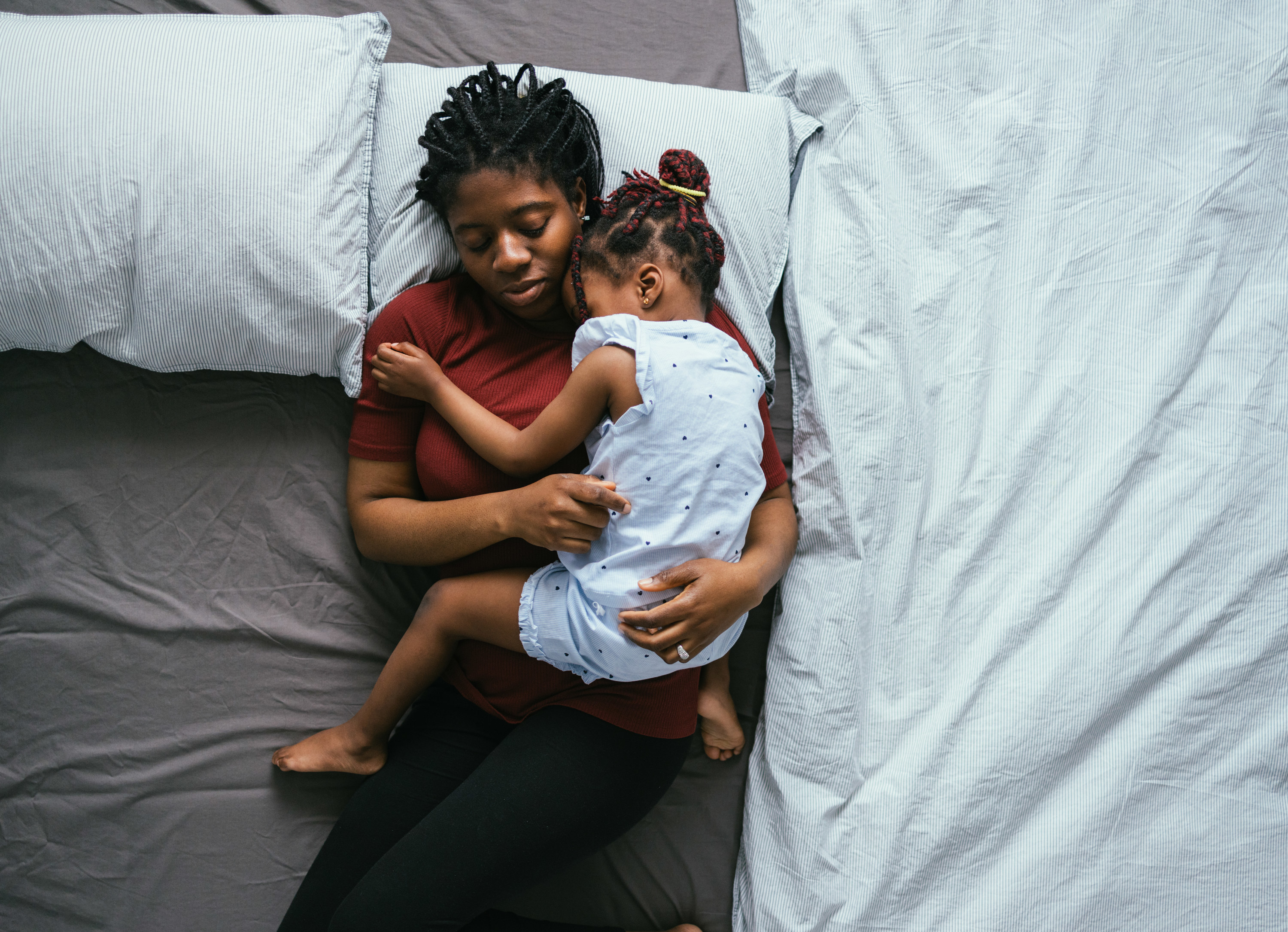 Tired mom cuddling with her daughter