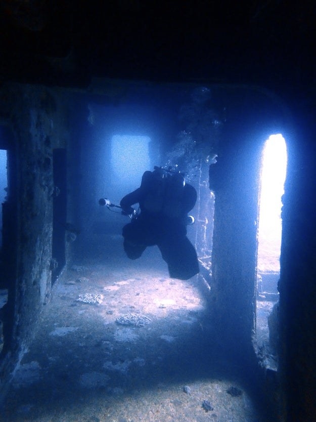 a diver swimming through ruins
