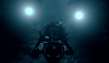 a diver holding a large camera and lights