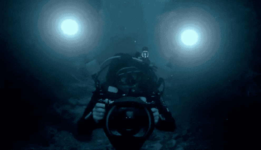 a diver holding a large camera and lights