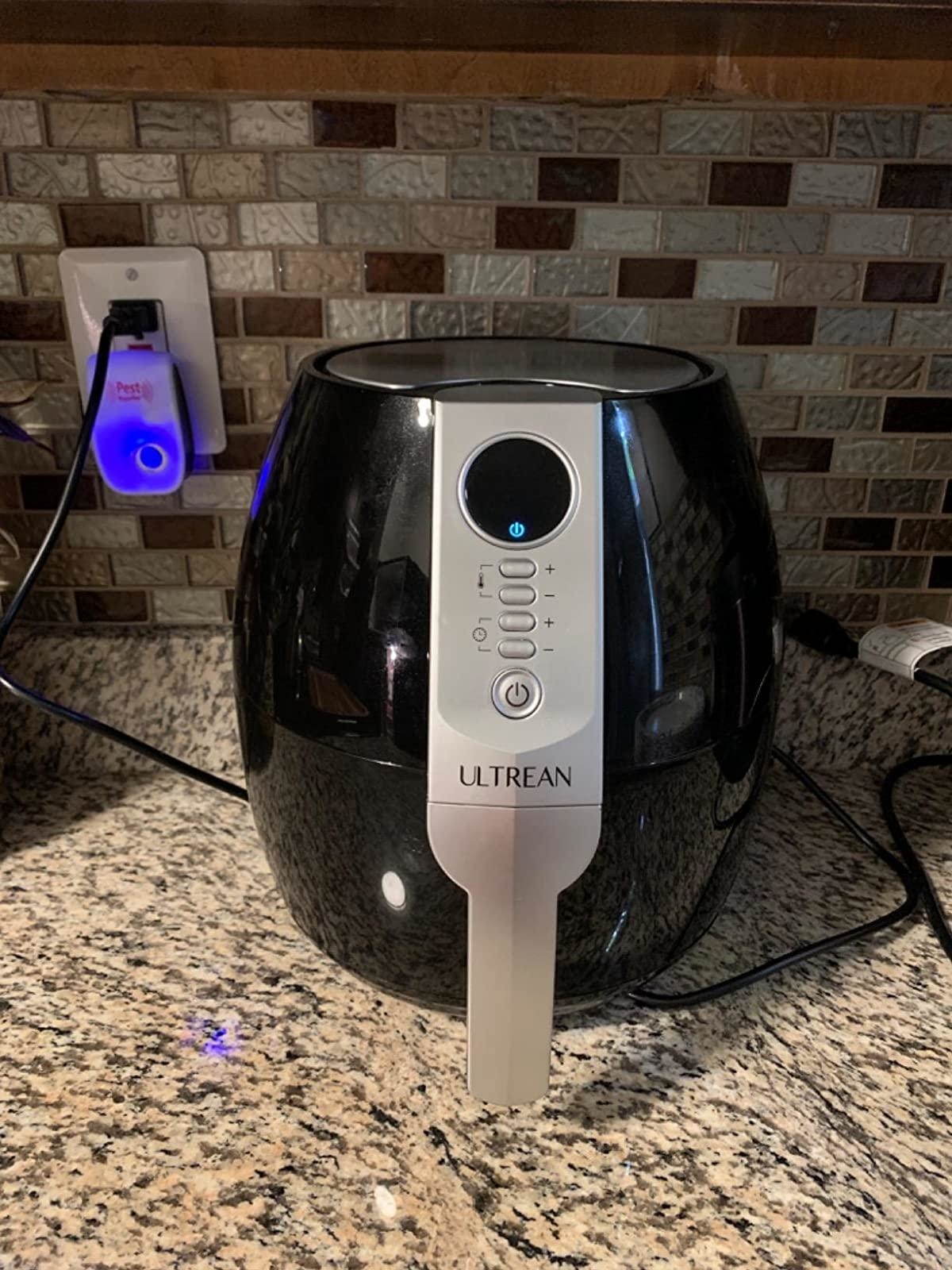 reviewer&#x27;s photo of the black air fryer sitting on the counter